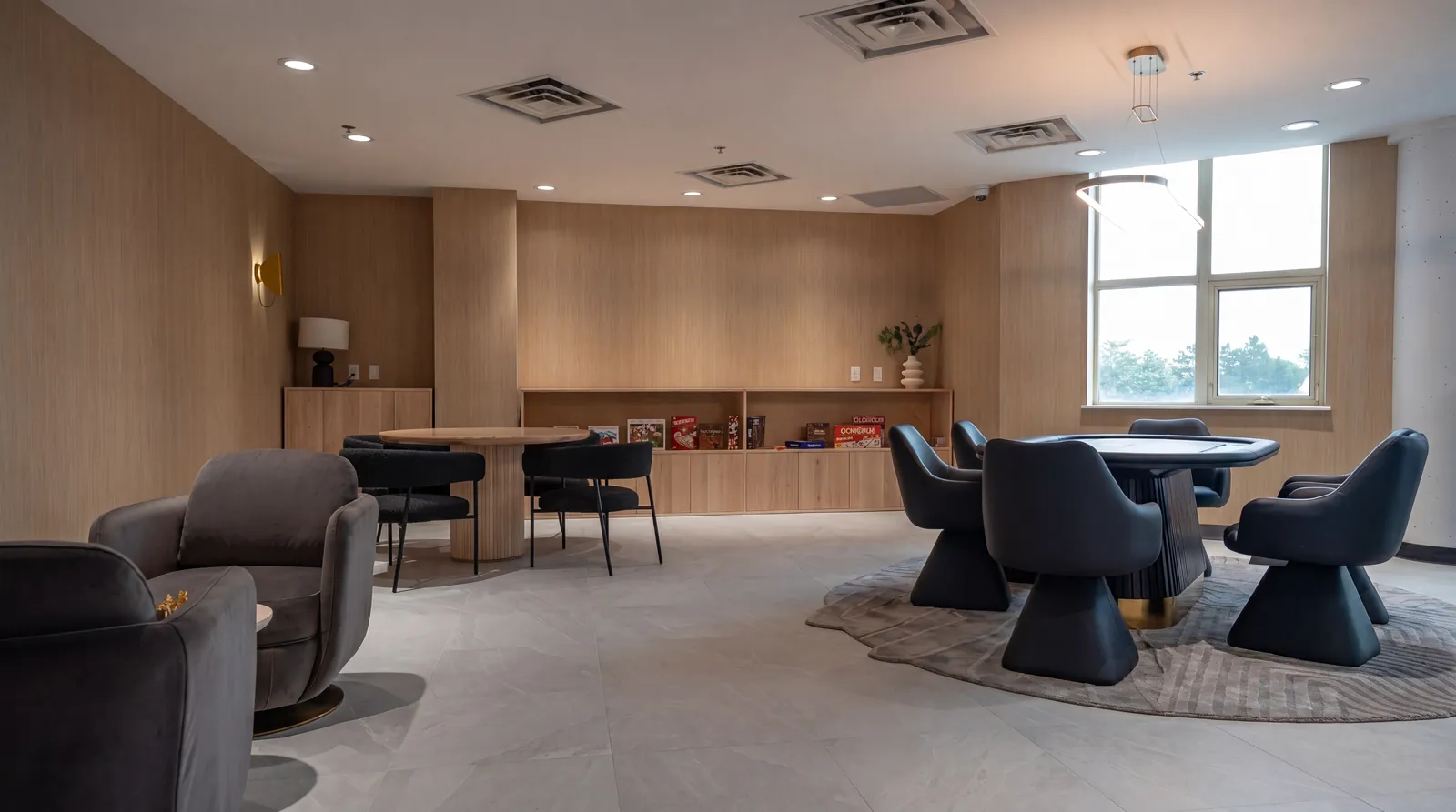 Games lounge with a poker table, sculptural swivel chairs and wood-panelled walls
