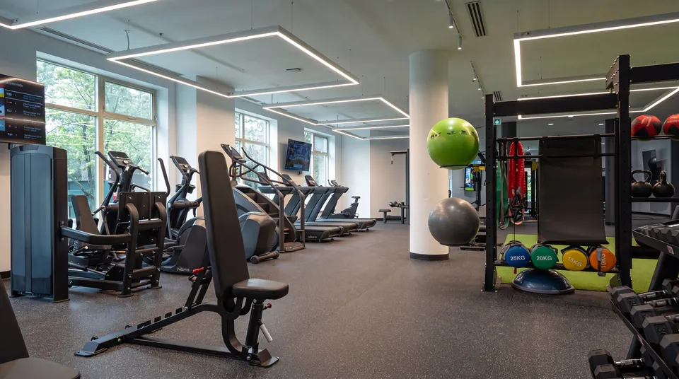 Fitness room with cardio machines, a weight bench and a functional training rack